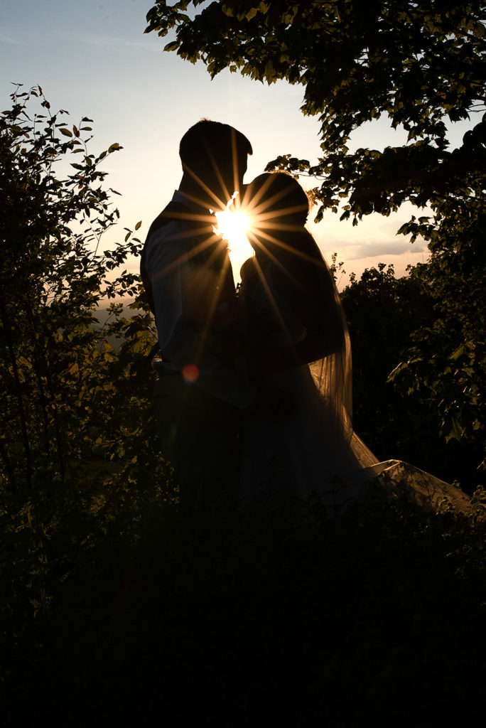 Sun burst silhouette image of a bride and groom.