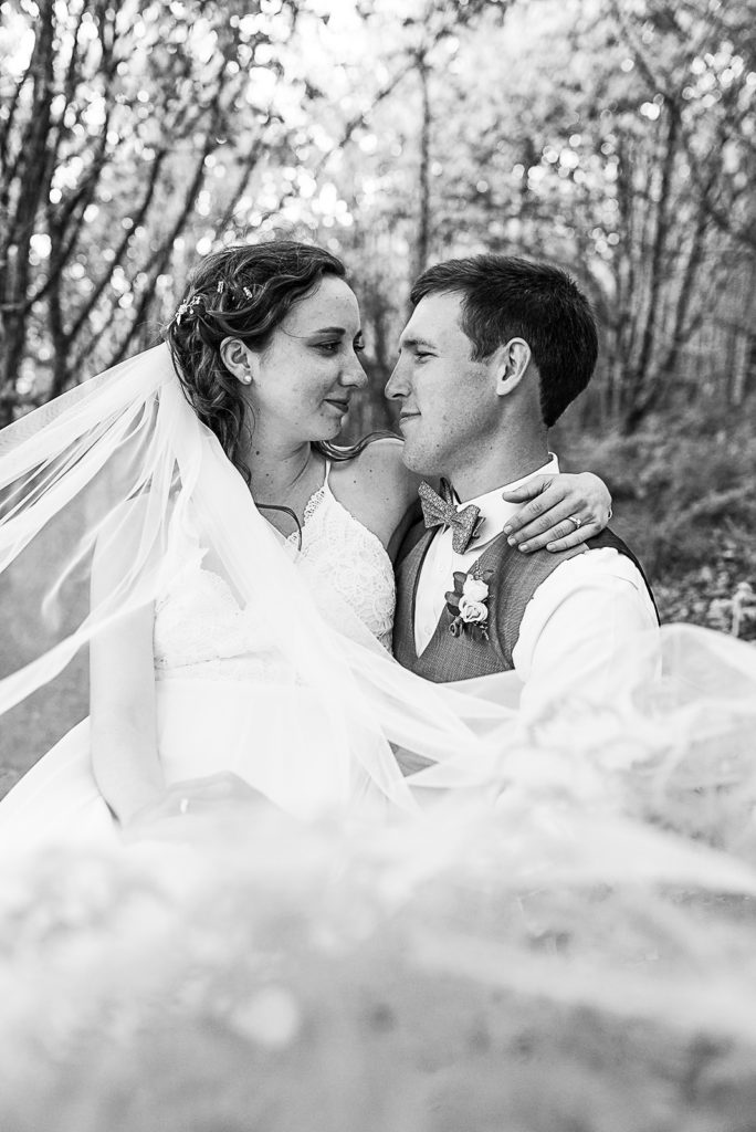 Black and white bride and groom portrait as he carries her away.