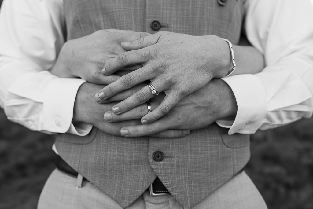 Black and white image of their hands showing off their new rings.