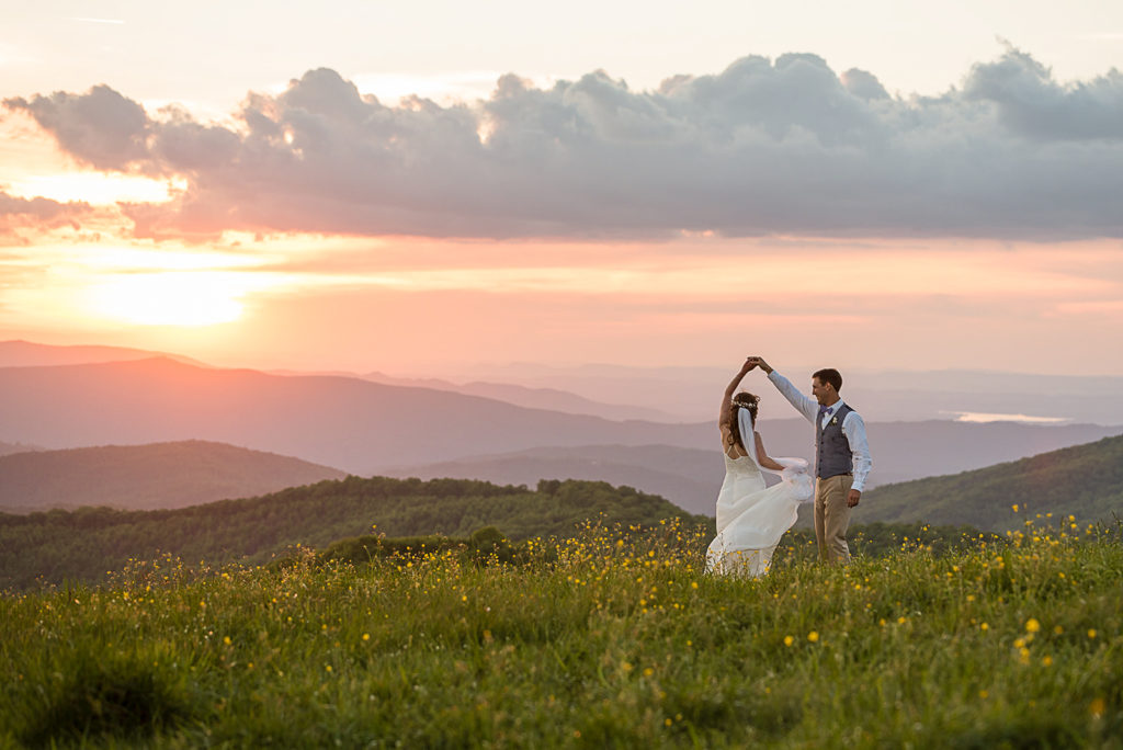Couple at sunset with mountain views in wedding attire