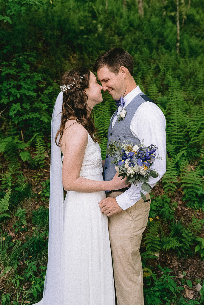 The bride and groom in nature after their max patch elopement surrounded by green ferns.