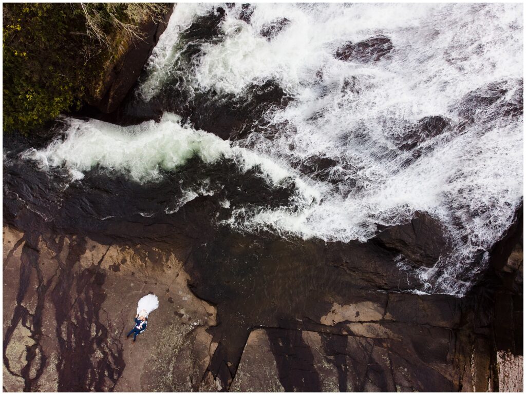 Drone shot of bride and groom at a waterfall