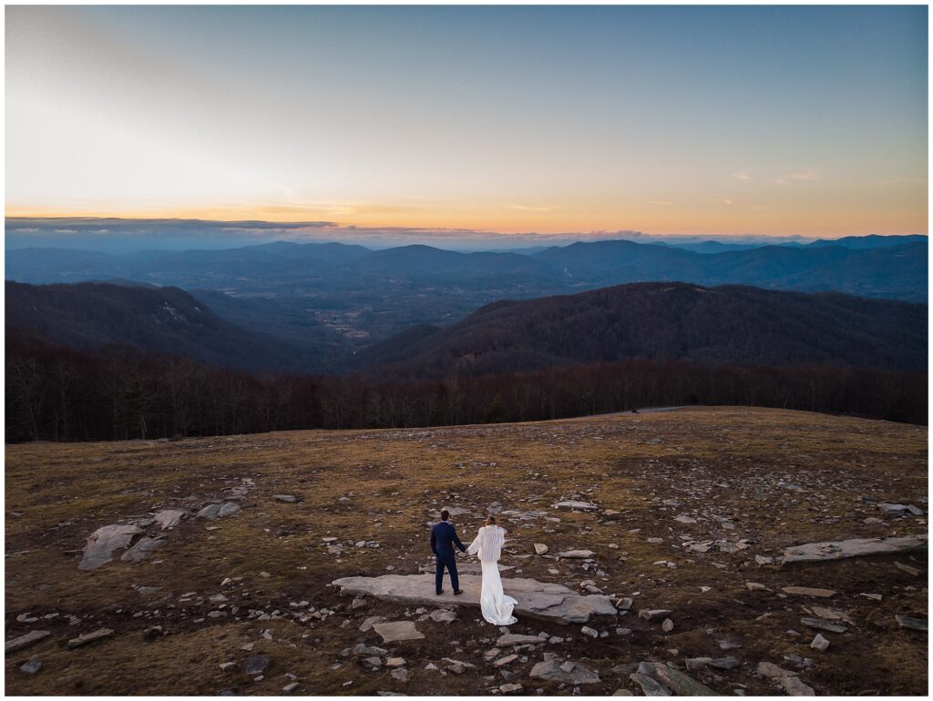 A drone photo of the sunset at Bearwallow mountain with the bride and groom in the distance.