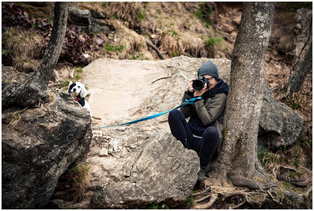 A behind the scenes photo of our Legacy and Legend team member capturing the shot on the rocks and holding the dog.