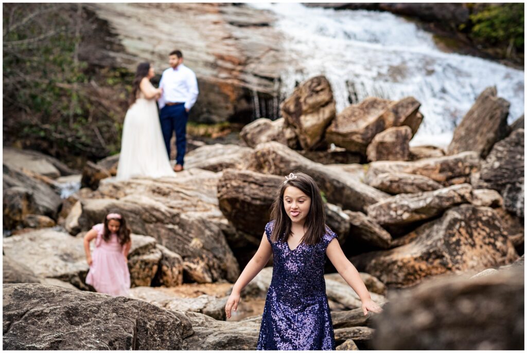 Silly family photos during an adventure session at a waterfall.