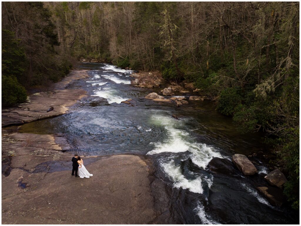 Drone photo of the couple together next to a waterfall and river.