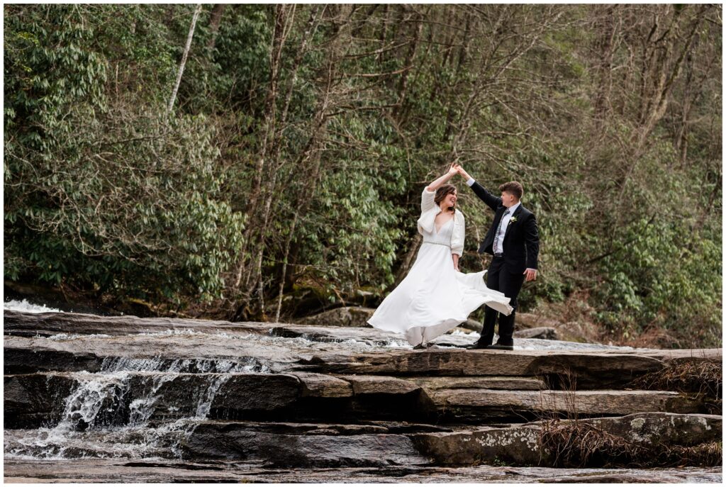 Twirling in her dress at their waterfall winter elopement.