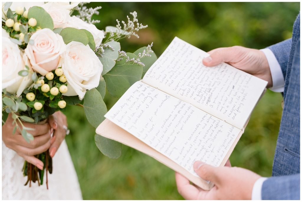 A groom holds open his vow book to read during their elopement.