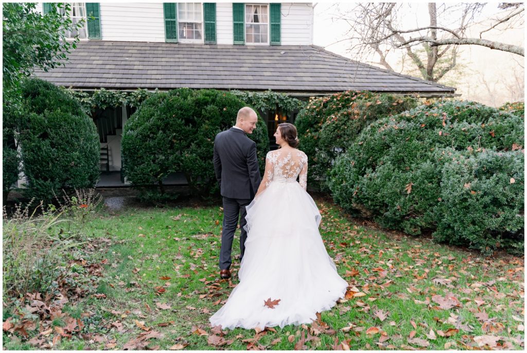 The bride and groom walking hand and hand at the Fall elopement at Sherrill's Inn.