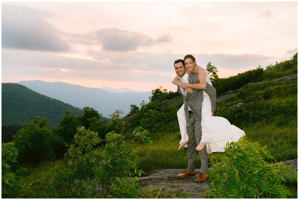 Piggy back ride elopement photo at sunset on a mountain in Asheville.